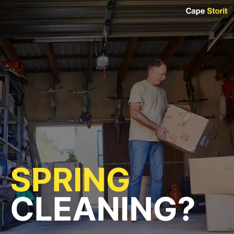 Man carrying a box while clearing out a garage